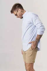 Camisa de hombre color crema, de corte clásico, con cuello abotonado y mangas largas.