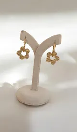 Aros tipo argolla con dije colgante en forma de flor realizado en acrílico con acabado brillante y destellos iridiscentes.