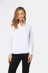 Blusa de manga larga en color azul marino, con escote en V y diseño de doble capa en el frente. Presenta puños elásticos y un pequeño aplique metálico decorativo en el ruedo.