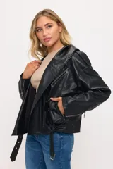 Chaqueta motera de cuero sintético color negro con capucha integrada. Presenta cierre frontal, cierres metálicos en los puños y cinturón ajustable en la cintura.