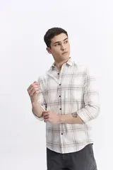 Camisa de manga larga confeccionada en viyela de algodón con diseño de cuadros en tonos azul y verde. Presenta cierre frontal con botones, cuello clásico y bolsillo en el pecho.