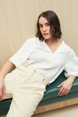 Pantalón negro de algodón, de tiro alto y corte recto, con bolsillos delanteros amplios con botones.