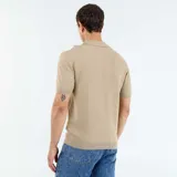 Remera de punto de manga corta en color beige con franjas verticales blancas, diseño con cuello tipo polo sin botones.