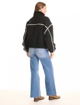 Campera negra de símil corderito, marca Elan. Tiene cuello alto, cierre frontal con solapa y botones, bolsillos inclinados en la parte delantera y ruedo y puños elastizados. Forro interno a tono.