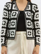 Cardigan abierto de tejido de punto calado con diseño geométrico y floral bicolor. Presenta escote en V, mangas largas y cierre frontal con tiras para anudar. Incluye detalles de vivos a contraste en el contorno del escote, puños y ruedo.