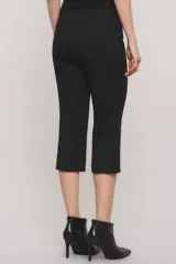 Pantalón capri negro de corte sastrero, confeccionado en tejido de punto grueso con elastano. Presenta calce slim, alforzas en el delantero, bolsillos ojal simulados, aberturas laterales en los bajos y cierre frontal con botón y broche metálico.