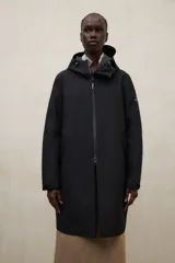 Campera larga impermeable Ecoalf modelo Neve, color negro, confeccionada en tejido técnico de tres capas con capucha ajustable, cierre frontal de cremallera y bolsillos laterales.