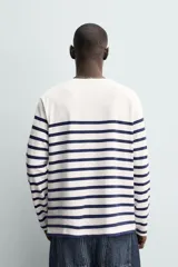 Remera de manga larga de corte relaxed fit, con diseño a rayas horizontales azul marino sobre base blanca y cuello redondo.