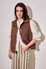 Chaleco oversize de algodón color marrón con efecto lavado, cuello solapa y cierre frontal con botones metálicos. Cuenta con bolsillos frontales diagonales.