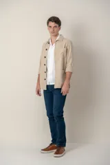 Sobre camisa color verde militar de lino con cuello clásico, manga larga con puños abotonados, cierre frontal con botones a tono y bolsillos de parche en el pecho.