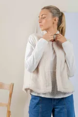 Chaleco de corderito color tostado, con cuello alto y diseño sin mangas.