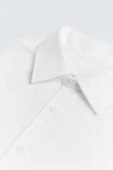 Camisa blanca de manga larga con cuello italiano y cierre frontal de botonadura. Corte regular fit.