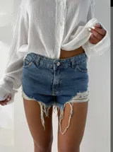 Short de jean azul con diseño de tiro medio, corte ajustado y terminaciones deshilachadas con detalle de tejido de red en los laterales.