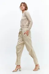 Pantalón de lino color fucsia, de corte relajado con cintura elástica y lazo ajustable. Presenta bolsillos ojal y detalle de presillas con botones en los tobillos que permiten ajustar el ruedo.