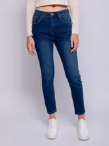 Pantalón de jean chupín color azul medio, con cinco bolsillos, presillas, botón y cierre metálico.