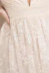 Vestido largo de fiesta con escote en V profundo, tirantes finos y falda con tajo lateral. Confeccionado en tela con brillos y detalles de encaje bordado en toda la prenda.