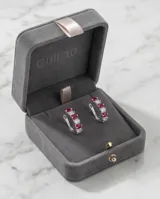 Caravanas de plata con diseño de aro pequeño, adornadas con una hilera de circonias blancas y fucsias en corte baguette.