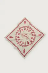 Bandana confeccionada en tejido de algodón de color beige, con diseño estampado en tono rojo que incluye cenefas geométricas, detalles florales y motivos gráficos centrales.