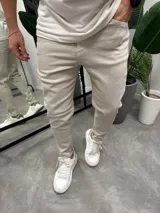 Jean de corte ajustado tipo skinny, color beige, con cierre frontal y bolsillos laterales. Confeccionado en tejido con elasticidad.