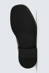 Bota de caña media fabricada en piel, con horma cuadrada y suela de goma a tono con volumen.