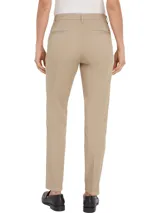 Pantalón chino color beige de sarga elástica, corte slim, con cierre de cremallera y botón, bolsillos traseros de ojal y logo de Tommy Hilfiger bordado en la parte trasera.
