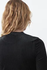 Top de manga larga confeccionado en tejido velvet acanalado con relieve vertical, de corte ajustado al cuerpo y cuello redondo.