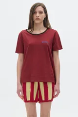 Remera color borgoña de algodón lavado, con cuello redondo ribeteado en negro, manga corta y corte oversized.