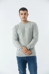 Sweater de punto con textura geométrica, color gris, de cuello redondo y manga larga. Presenta puños y ruedo acanalados con detalle de borde en color oscuro y logo bordado en el pecho.