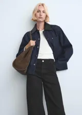 Pantalón de jean negro de corte recto y tiro alto, con diseño de pierna ancha y terminaciones deshilachadas en el ruedo.