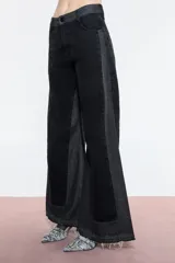 Pantalón de jean negro con corte wide leg y tiro alto. Diseño con dos tipos de denim, uno negro y otro gris, con recortes que resaltan la variación de telas.