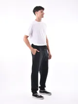 Pantalón deportivo negro, tipo jogging, con cordón ajustable en la cintura y puños elásticos en los tobillos.