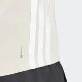 Remera de entrenamiento Adidas color beige, con cuello redondo, mangas cortas y las icónicas tres rayas de la marca en los laterales. Presenta el logo de Adidas estampado en el pecho y tecnología de absorción de humedad.