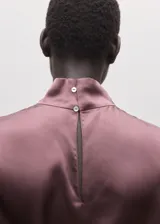 Blusa de seda con cuello alto y diseño sin mangas, de corte recto y acabado satinado.
