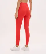 Pantalón legging deportivo de tiro alto, confeccionado en microfibra elástica de color rojo. Presenta un diseño ajustado al cuerpo con costuras reforzadas que brindan soporte y libertad de movimiento.