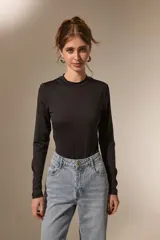 Body de manga larga confeccionado en poliamida, con diseño ajustado al cuerpo, cuello a la base y cierre inferior con broches.