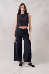Pantalón negro de corte ancho, tiro alto y textura suave.