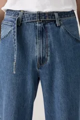 Pantalón de jean celeste de corte amplio, con cintura alta y diseño de cinturón incorporado.