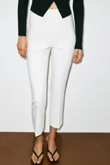 Pantalón mini flare de tiro medio, color negro, con diseño evasé y raya central marcada. Cuenta con cierre lateral mediante cremallera oculta.