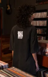 Remera de manga corta con cuello redondo y calce oversize, color negro con efecto nevado. Presenta un estampado gráfico frontal con el logo de la banda The Prodigy y elementos artísticos.
