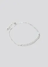 Pulsera plateada con eslabones gruesos y cierre ajustable con cadena fina y bolitas.