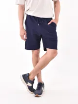 Bermuda deportiva azul marino con cintura elástica ajustable con cordón.