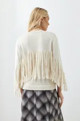 Sweater beige claro de tejido de punto con cuello redondo y mangas largas con flecos.