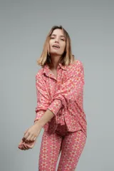 Camisa de manga larga color rosado con estampado de flores anaranjadas y blancas.