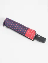 Paraguas plegable automático con estampado de lunares blancos sobre fondo rojo y lunares rojos sobre fondo azul.