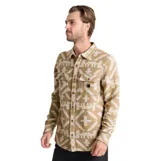 Camisa de franela Roark modelo Nordsman Jacquard, de corte recto y manga larga. Presenta un estampado geométrico inspirado en textiles tradicionales en tonos marrón y beige, con cierre frontal de botones a presión y dos bolsillos con solapa en el pecho.