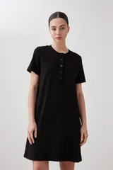 Vestido midi negro de corte recto, con cuello redondo y botones frontales.