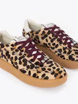 Zapatilla de estilo urbano confeccionada en cuero vacuno con pelo y estampado animal print de leopardo. Presenta cordones en color bordó, suela de caucho color caramelo, detalle de cristal en la zona de los cordones y apliques de cuero en contraste.