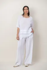 Blusa de lino color blanco, de corte amplio, con escote redondo, mangas cortas y detalle de guarda calada horizontal en la parte inferior.