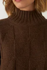 Buzo de tejido de punto industrial color marrón oscuro, con cuello medio y diseño de bloques cuadrados en relieve.