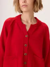 Sweater de punto color rojo, con mangas largas ranglán, cuello redondo acanalado y dobladillo redondeado.